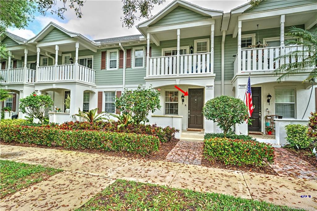 3073 East Community Drive Jupiter, FL 33458 - Photo 1 of 85 a front view of a house with a yard and potted plants