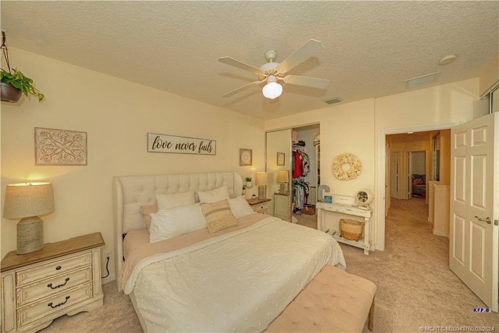 3073 East Community Drive Jupiter, FL 33458 - Photo 22 of 85 a spacious bedroom with a bed and a chandelier