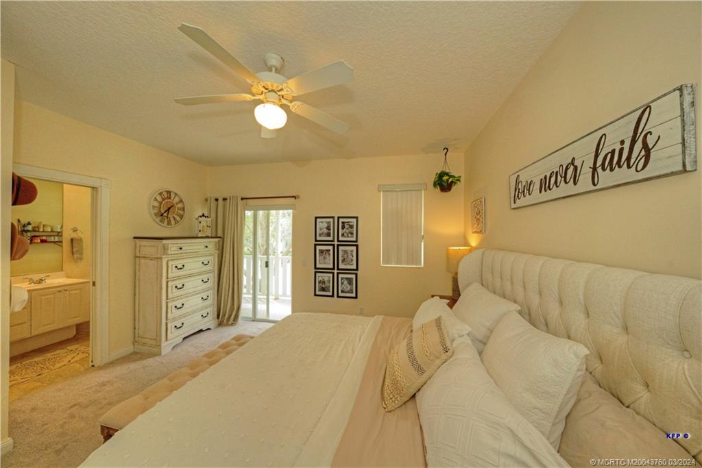 3073 East Community Drive Jupiter, FL 33458 - Photo 24 of 85 a bedroom with a bed and a chandelier