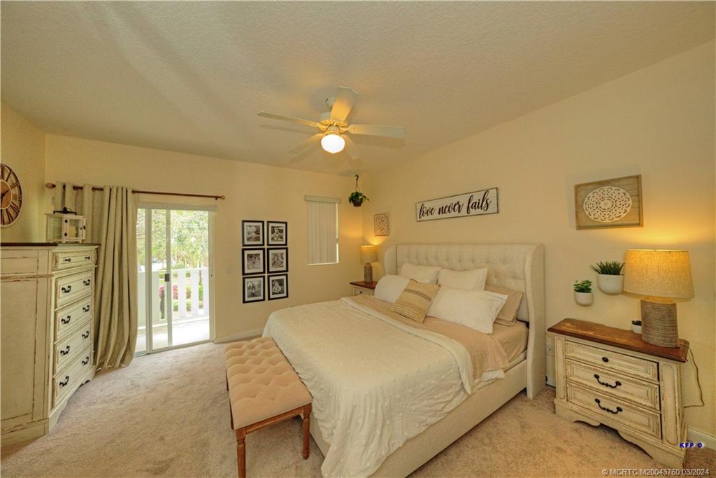 3073 East Community Drive Jupiter, FL 33458 - Photo 25 of 85 a bedroom with a bed and a chandelier