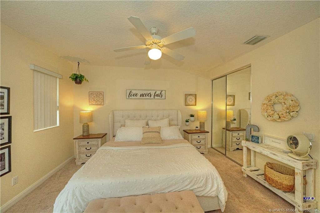 3073 East Community Drive Jupiter, FL 33458 - Photo 26 of 85 a bedroom with a bed and wooden floor