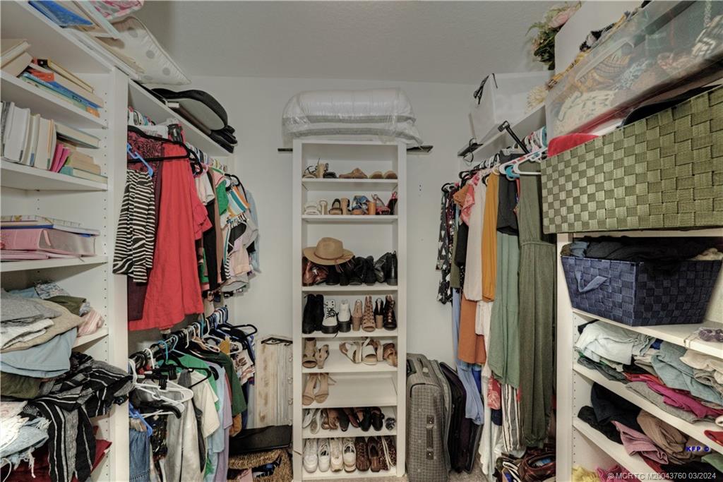 3073 East Community Drive Jupiter, FL 33458 - Photo 30 of 85 a view of walk in closet with clothes and shoes