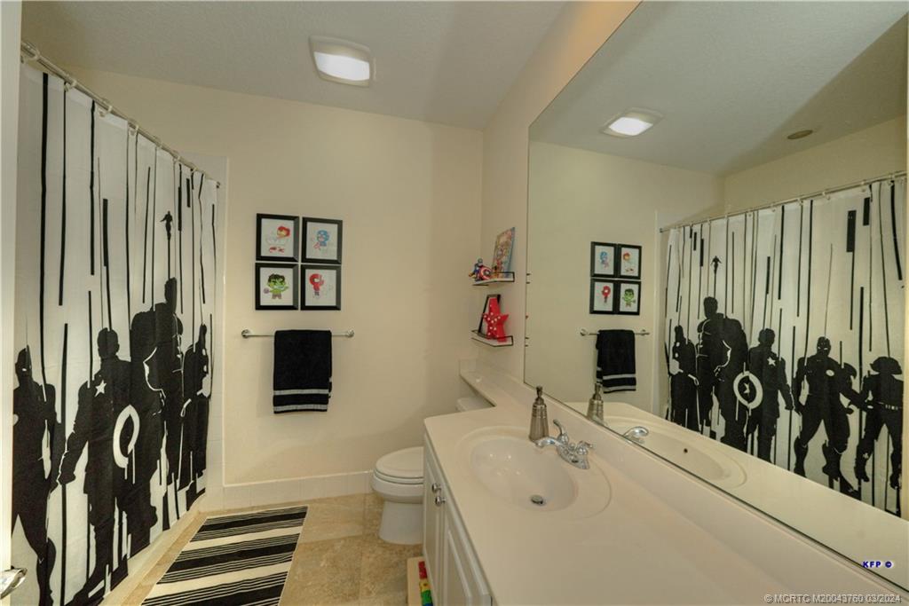 3073 East Community Drive Jupiter, FL 33458 - Photo 39 of 85 a bathroom with a sink and mirror with toilet