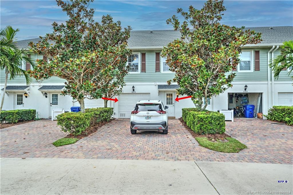 3073 East Community Drive Jupiter, FL 33458 - Photo 43 of 85 a car parked in front of a white house