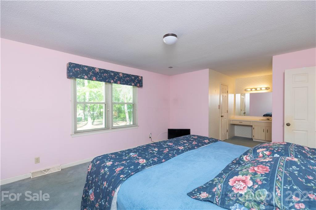 11 Friendfield Court Fort Mill, SC 29715 - Photo 16 of 32 a bedroom with a bed and a chandelier