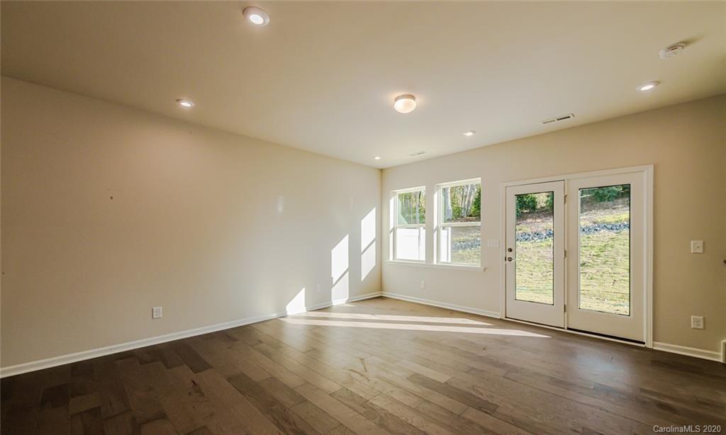 512 Madison Falls, Unit 6 Fort Mill, SC 29708 - Photo 12 of 27 an empty room with wooden floor and windows with curtains