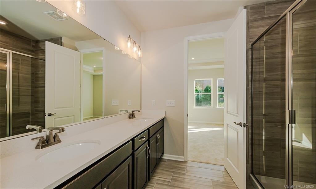 512 Madison Falls, Unit 6 Fort Mill, SC 29708 - Photo 21 of 27 a bathroom with a double vanity sink a mirror and a shower