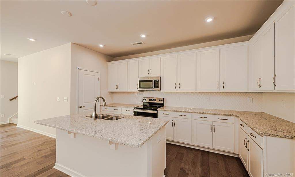512 Madison Falls, Unit 6 Fort Mill, SC 29708 - Photo 5 of 27 a kitchen with granite countertop a sink stainless steel appliances and white cabinets