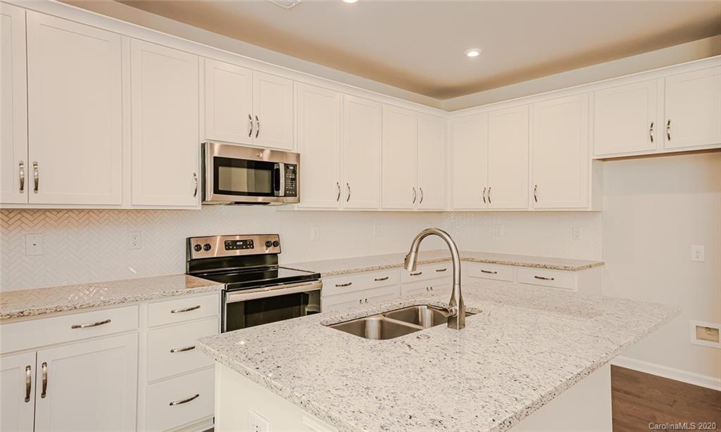 512 Madison Falls, Unit 6 Fort Mill, SC 29708 - Photo 8 of 27 a kitchen with granite countertop a sink a stove and cabinets