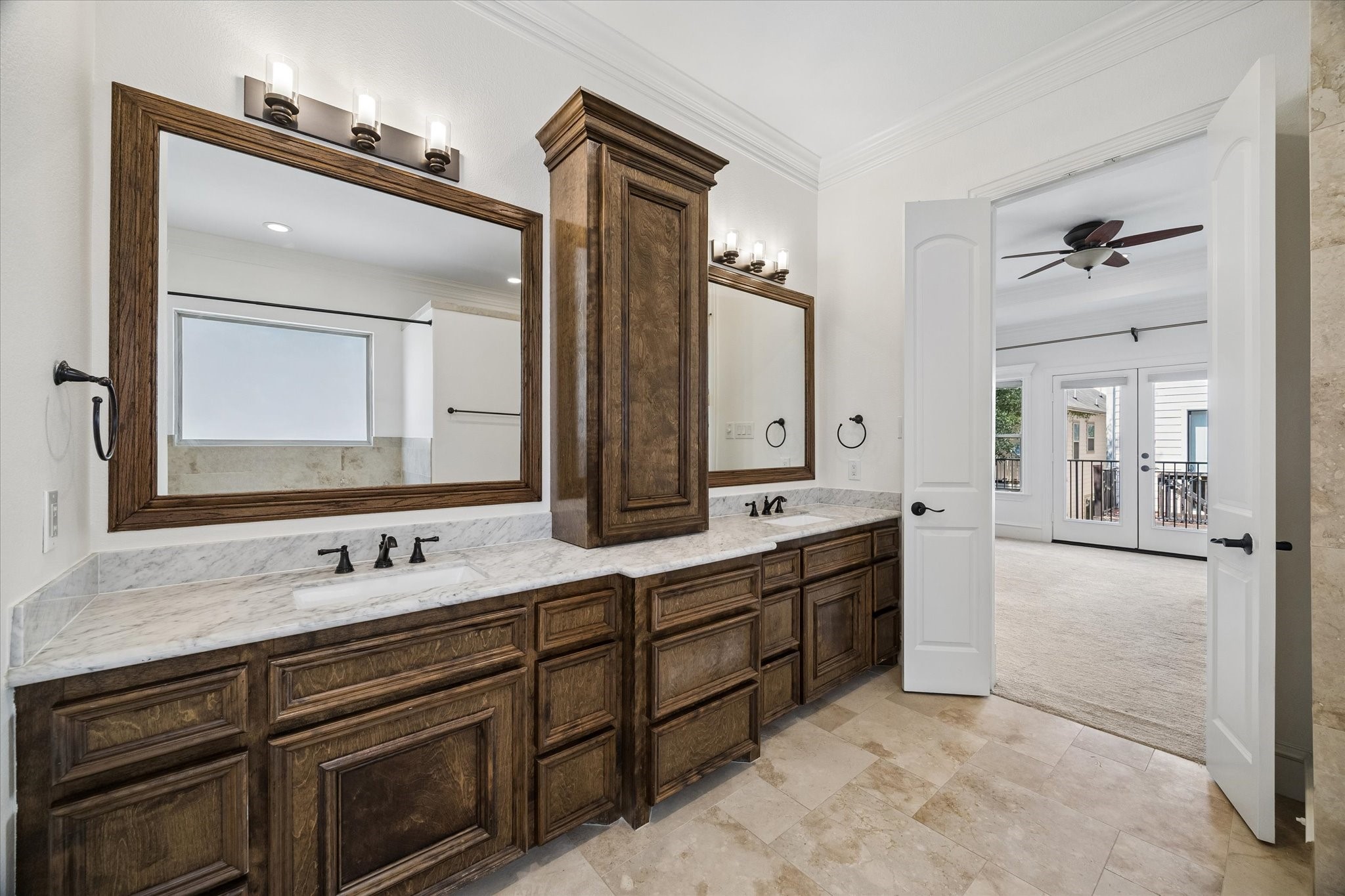 5334 Inker Street Houston, TX 77007 - Photo 18 of 39 Primary bath featuring an expansive vanity with abundant cabinetry, sleek modern lighting fixtures, and elegant travertine flooring that enhances the room's high-end aesthetic.