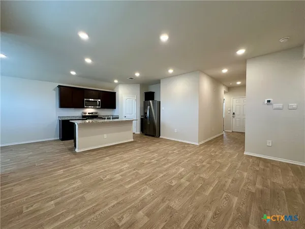 a kitchen with stainless steel appliances granite countertop a sink a stove and a granite counter tops with wooden floors