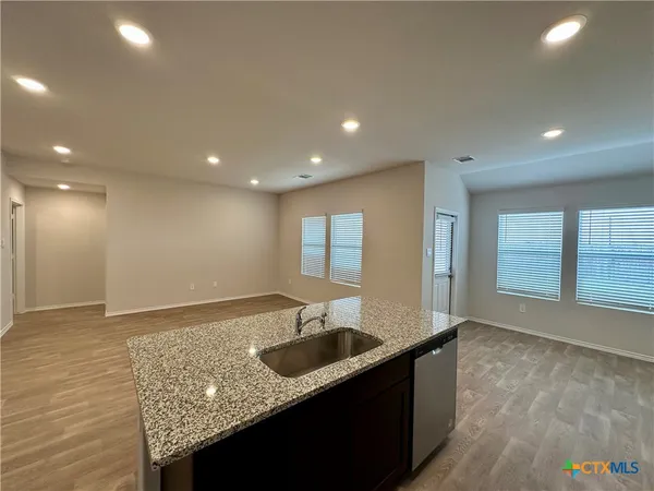 a large kitchen with stainless steel appliances kitchen island granite countertop a large counter top and a stove