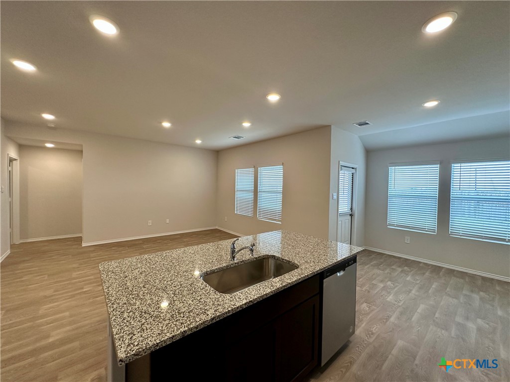 713 Signe Seguin, TX 78155 - Photo 4 of 18 a kitchen with stainless steel appliances granite countertop a sink a stove and a granite counter tops with wooden floors