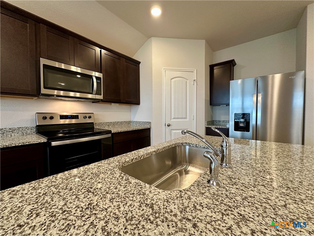 713 Signe Seguin, TX 78155 - Photo 6 of 18 a kitchen with stainless steel appliances granite countertop a refrigerator a stove top oven a sink and dishwasher