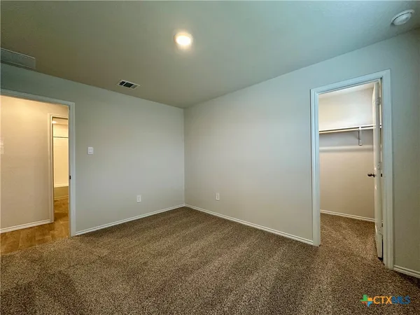 an empty room with closet and windows