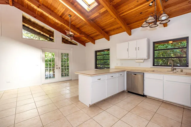 a kitchen with a stove a sink dishwasher and a large window
