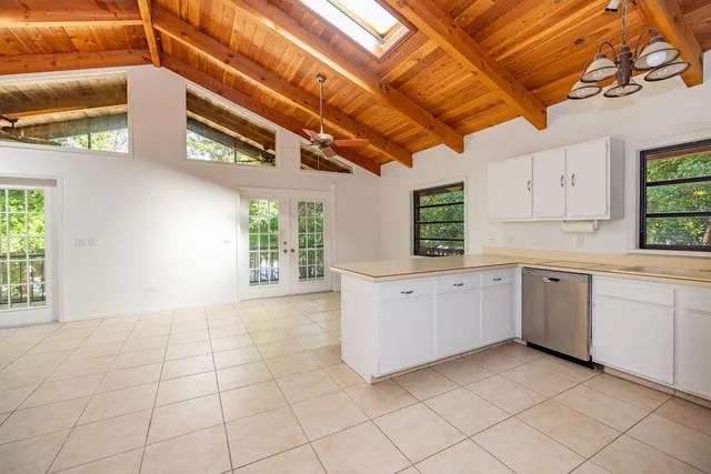 a kitchen with a white cabinets and window