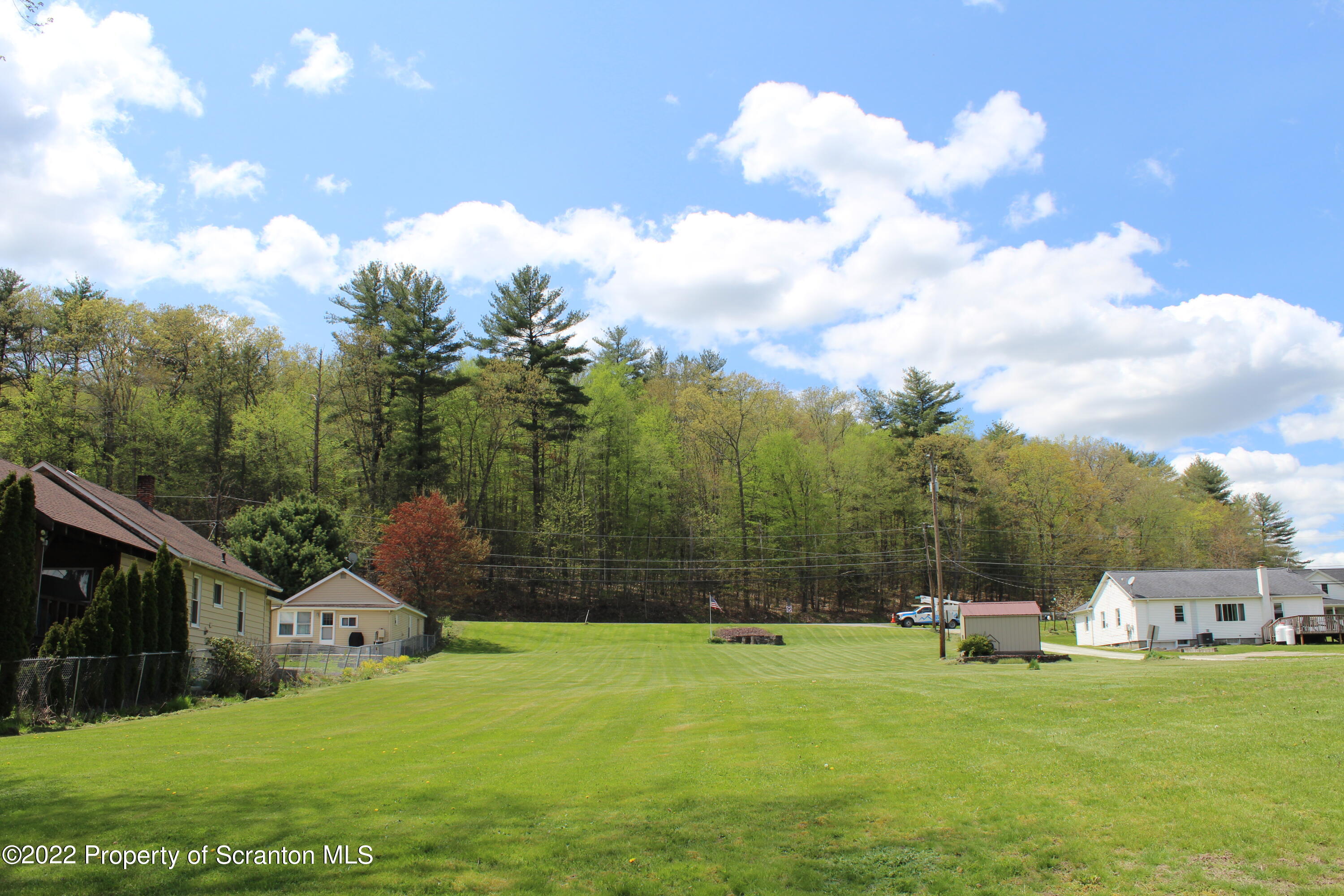 108 Frear Lane Factoryville, PA 18419 - Photo 6 of 9 a backyard of a house with table and chairs and a large tree