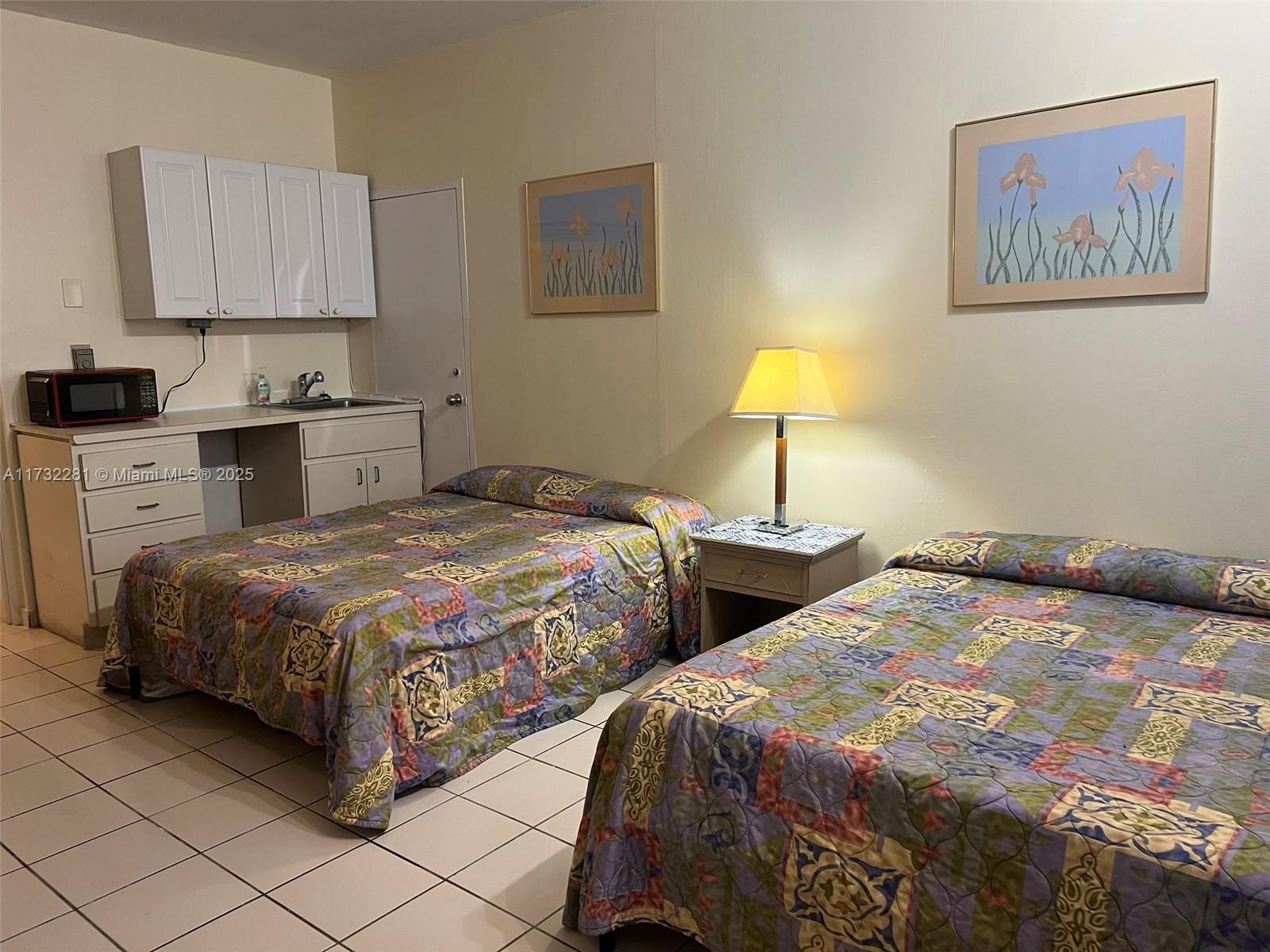 26 Diplomat Parkway, Unit 2332 Hallandale Beach, FL 33009 - Photo 12 of 18 a bedroom with two beds and a lamp on table