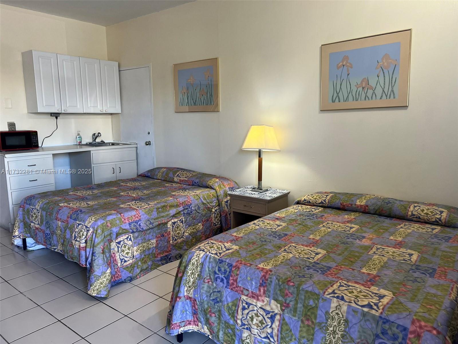 26 Diplomat Parkway, Unit 2332 Hallandale Beach, FL 33009 - Photo 3 of 18 a bedroom with double bed and a lamp