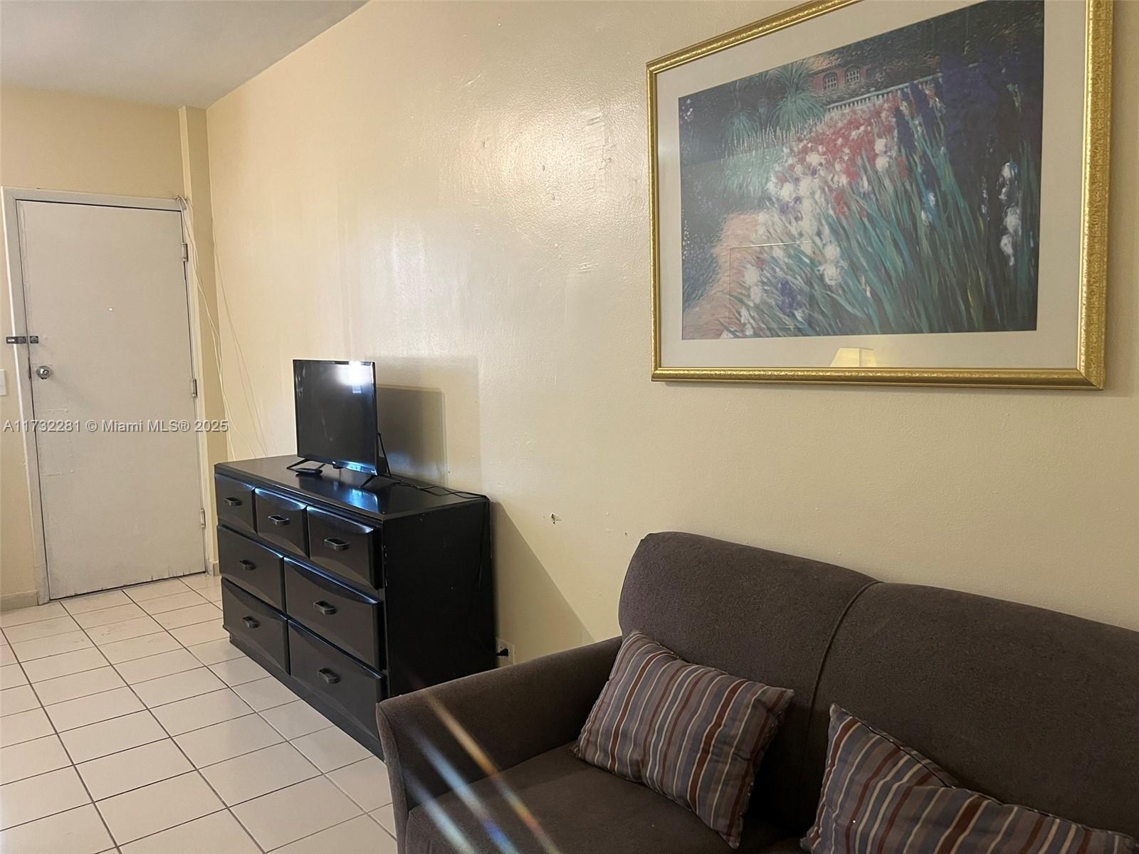 26 Diplomat Parkway, Unit 2332 Hallandale Beach, FL 33009 - Photo 6 of 18 a living room with furniture and wooden floor
