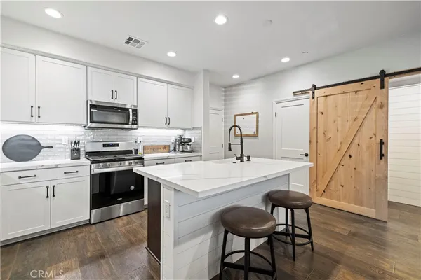 a kitchen with granite countertop a sink stove and refrigerator