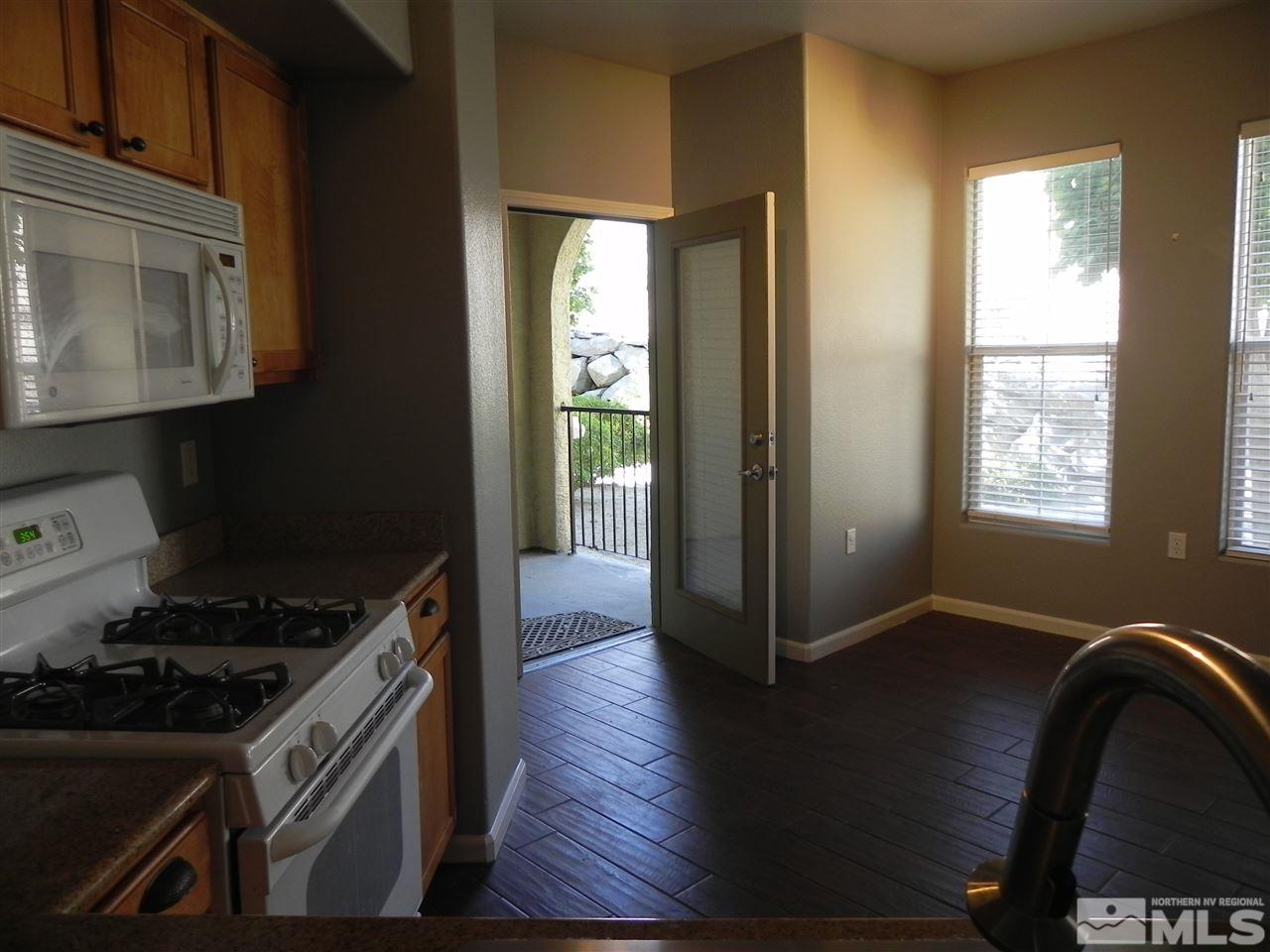 9050 Double R Boulevard, Unit 1112 Reno, NV 89521 - Photo 8 of 24 a kitchen with granite countertop a stove and a refrigerator