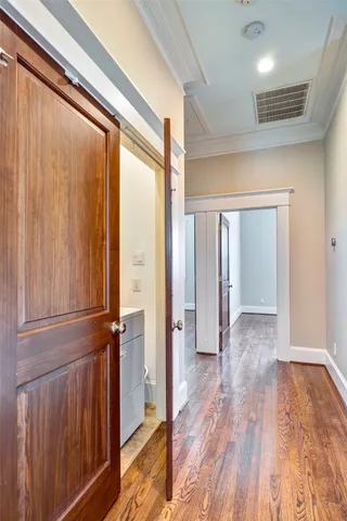 a view of a hallway with wooden floor and closet area