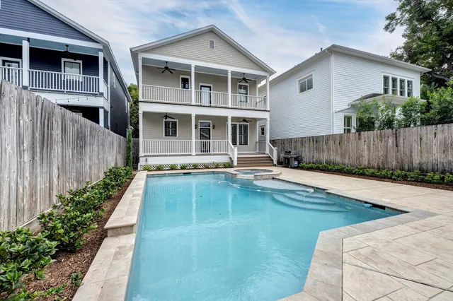 a view of a house with pool and wooden fence