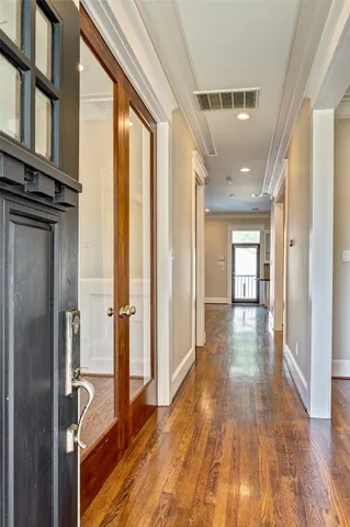 a view of a hallway with wooden floor and staircase