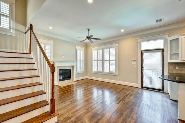 a view of a livingroom with wooden floor fireplace and staircase