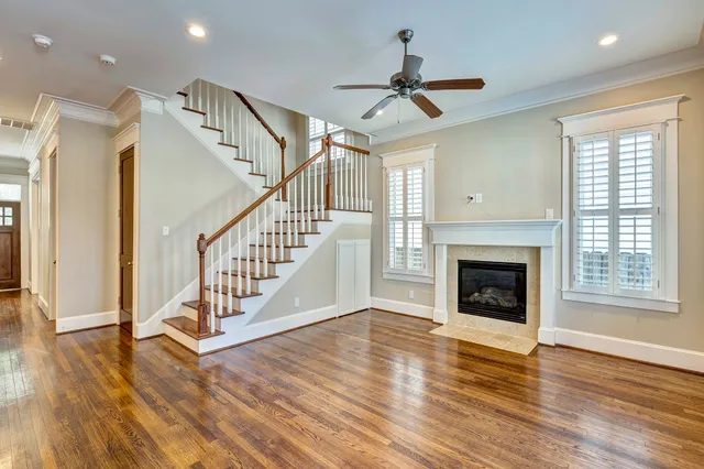 a view of a livingroom with wooden floor a fireplace and windows