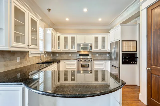 a kitchen with stainless steel appliances granite countertop a sink and cabinets