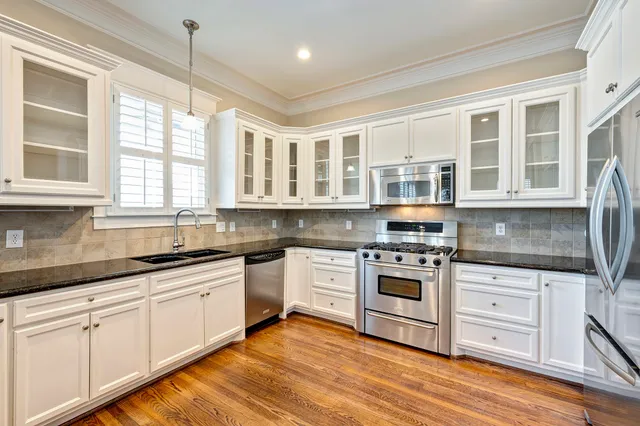 a kitchen with stainless steel appliances granite countertop a stove and cabinets
