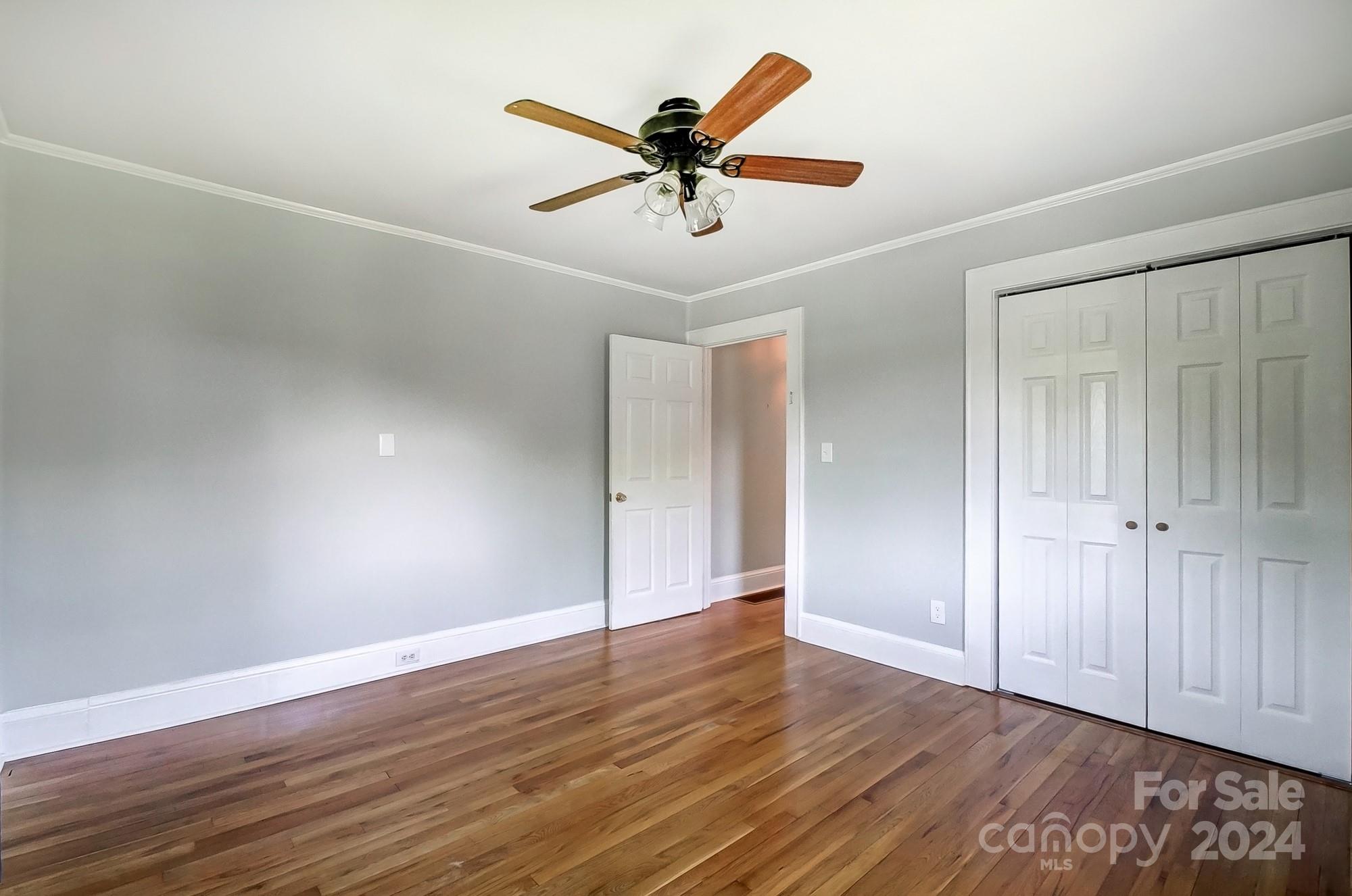 3760 Woodleaf Road Salisbury, NC 28147 - Photo 16 of 31 an empty room with wooden floor ceiling fan and windows