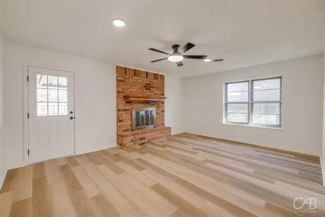 a view of empty room with window and ceiling fan