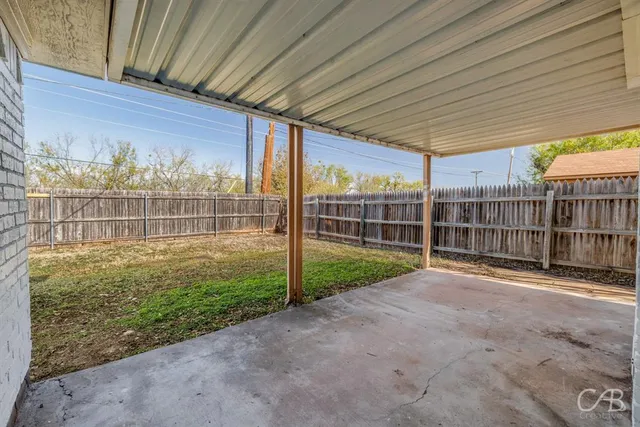 a view of a backyard with wooden fence