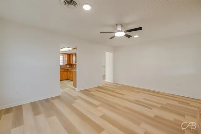 a view of empty room with ceiling fan