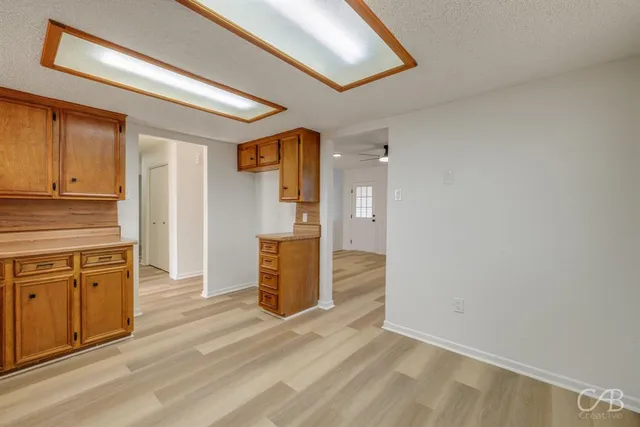 a view of a kitchen with wooden floor and cabinets