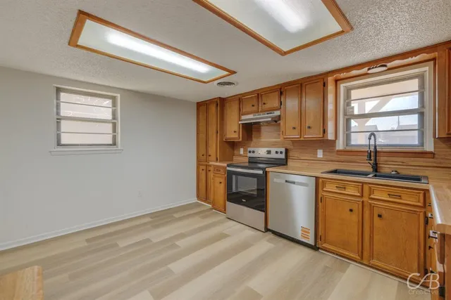 a kitchen with a refrigerator stove top oven and sink