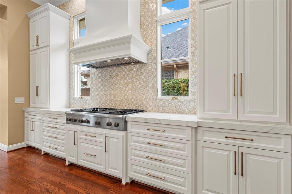 1600 Ridgewood Drive Waco, TX 76710 - Photo 16 of 40 a kitchen with granite countertop white cabinets and a stove with wooden floor