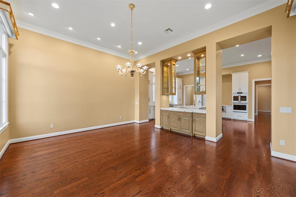 1600 Ridgewood Drive Waco, TX 76710 - Photo 19 of 40 a view of an empty room with wooden floor and a kitchen