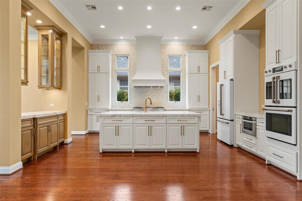 1600 Ridgewood Drive Waco, TX 76710 - Photo 10 of 40 a large white kitchen with stainless steel appliances granite countertop a stove a sink a refrigerator and white cabinets with wooden floor