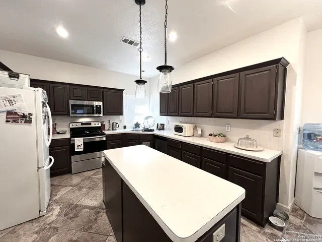a kitchen with stainless steel appliances a stove sink refrigerator and cabinets
