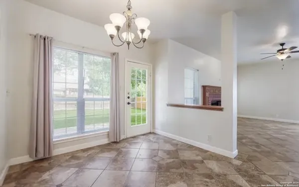 a view of a hallway with chandelier and glass door