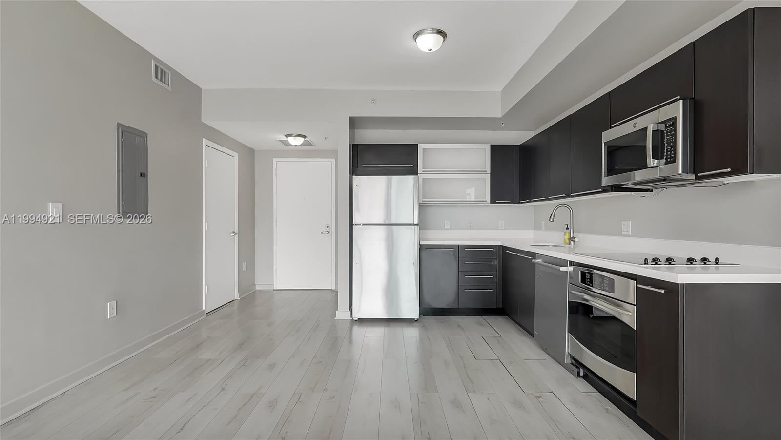 90 Southwest 3rd Street, Unit 3003 Miami, FL 33130 - Photo 16 of 47 a kitchen with stainless steel appliances a stove a microwave and white cabinets