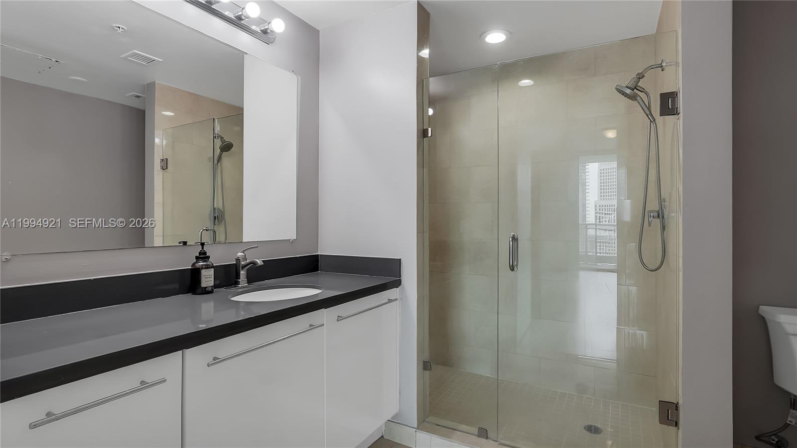 90 Southwest 3rd Street, Unit 3003 Miami, FL 33130 - Photo 34 of 47 a bathroom with double vanity and a mirror