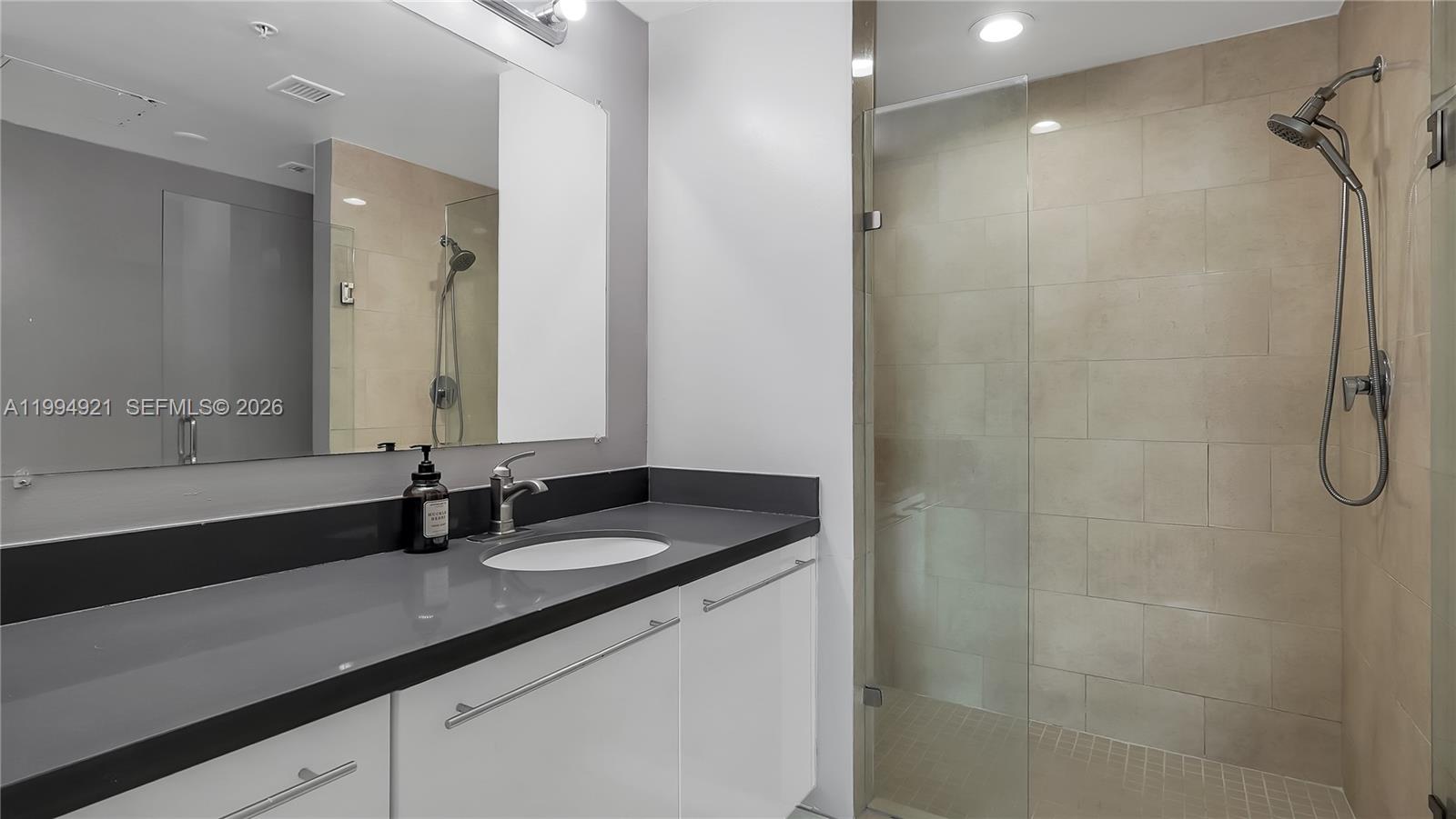 90 Southwest 3rd Street, Unit 3003 Miami, FL 33130 - Photo 36 of 47 a bathroom with a granite countertop sink and a mirror