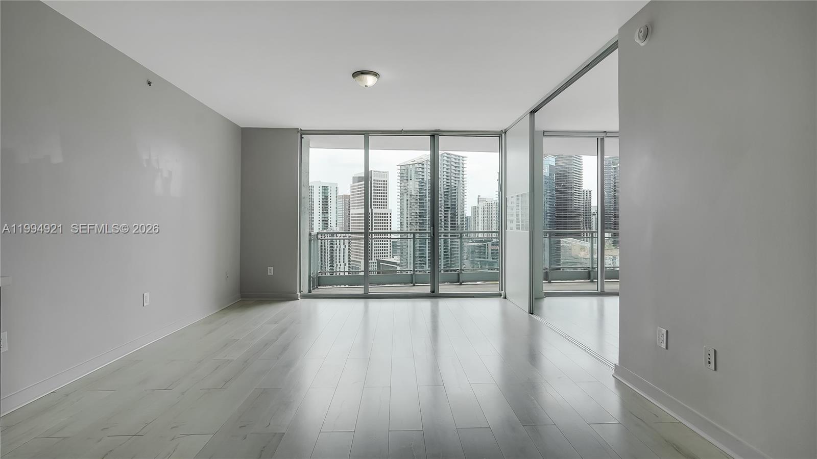 90 Southwest 3rd Street, Unit 3003 Miami, FL 33130 - Photo 5 of 47 a view of an empty room with wooden floor and a window