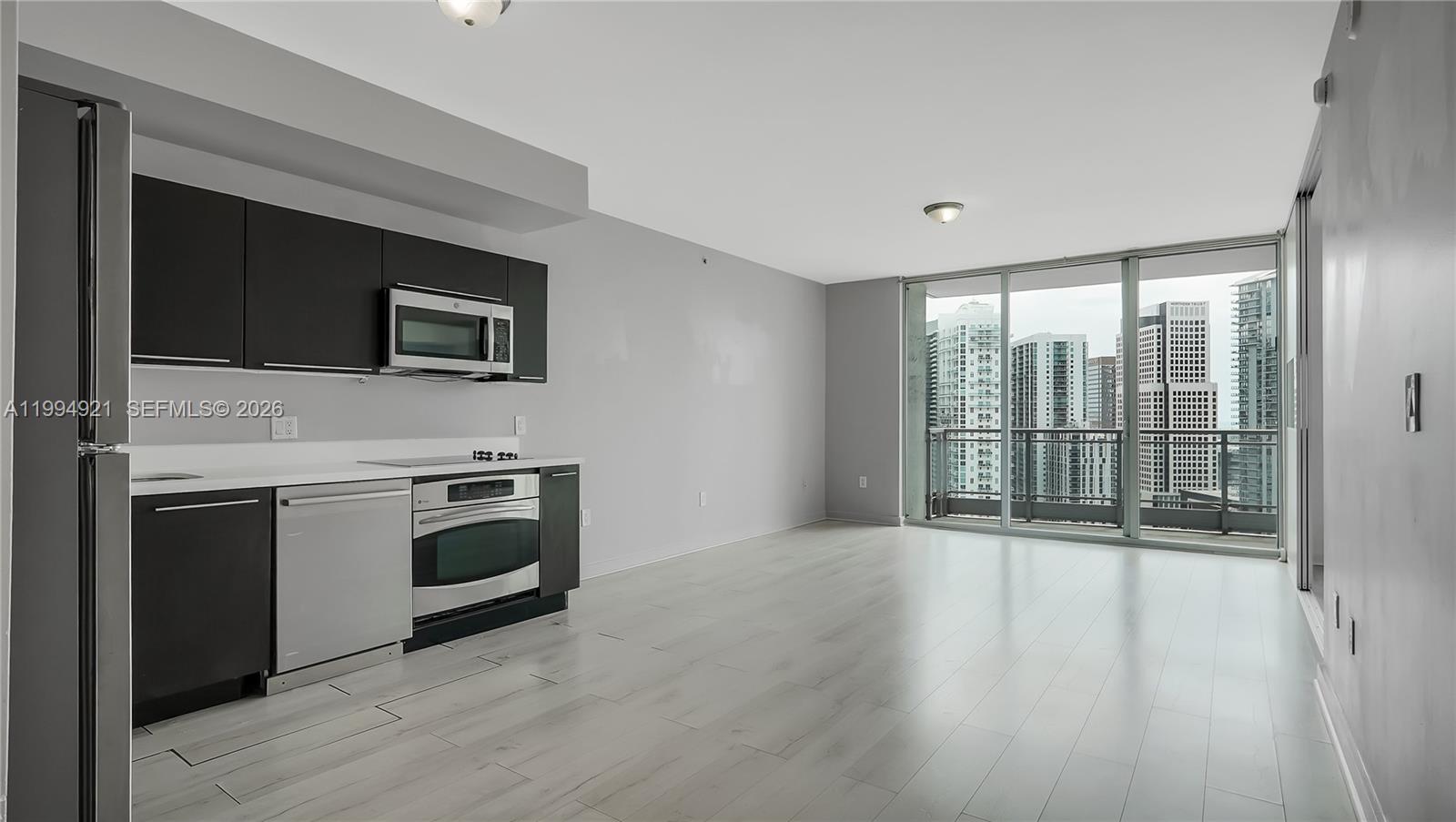 90 Southwest 3rd Street, Unit 3003 Miami, FL 33130 - Photo 7 of 47 a view of a kitchen with a flat screen tv a stove and a window